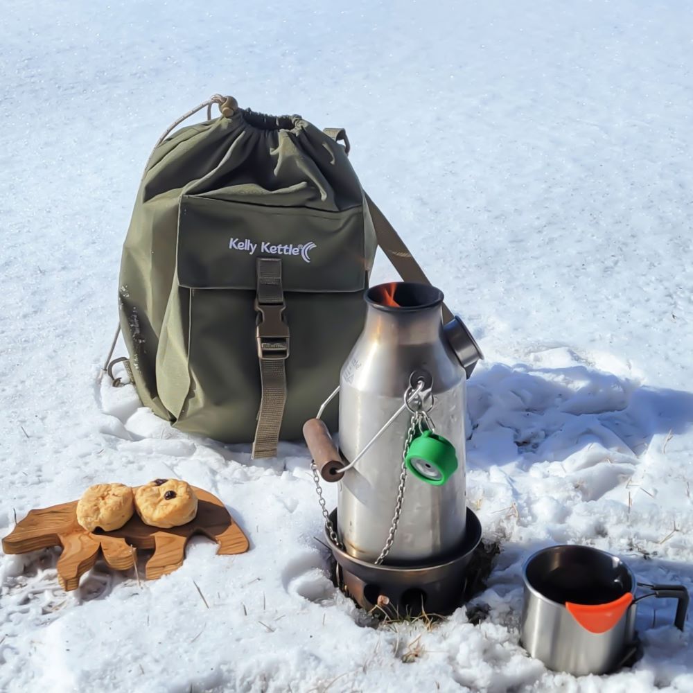 Kelly Kettle heavy duty green kit bag with shoulder strap for camping gear storage
outdoors in snow